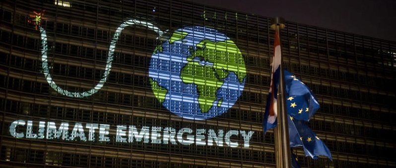 Greenpeace project an image of the Earth as a bomb with a lit fuse onto European Commission.