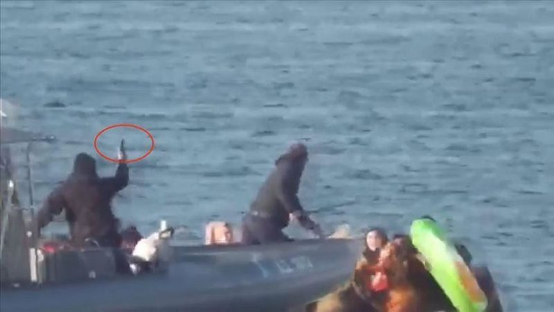 Greek border police beat a Syrian woman on a boat with a truncheon while another uniformed officer wields a pistol