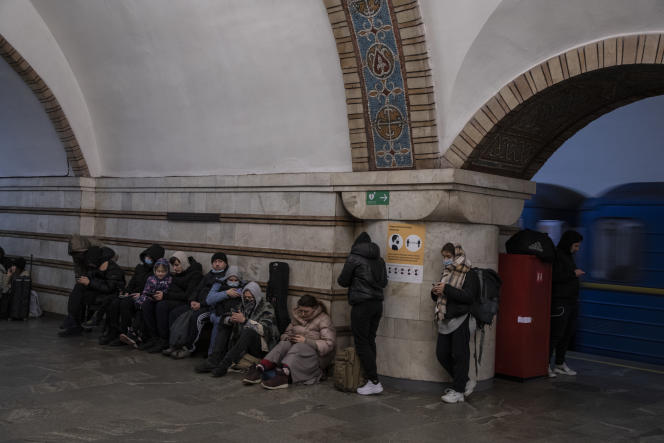 Workers and children take refuge in Kiev subway after the first air raid sirens as columns of cars leave the city