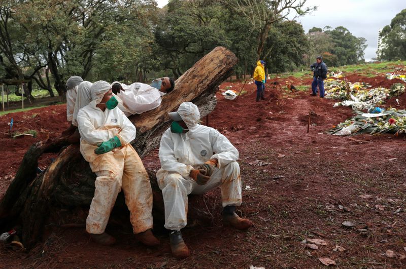 Grave diggers rest next to a mass grave of Covid victims in São Paulo.