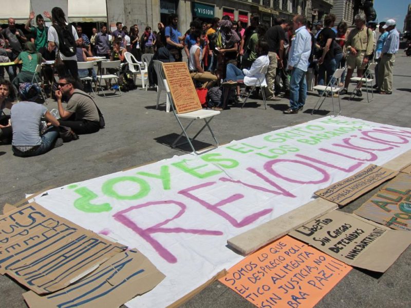 Acampada en Sol en la mañana del 16 de mayo de 2011. Se despliega la profusión de consignas y versos que sería característica del movimiento 15M