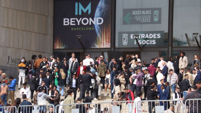 Público, en su mayoría veinteañeros de clase trabajadora, espera en la puerta del Palacio Olímpico de Badalona en una pausa del evento cripto de IM Academy