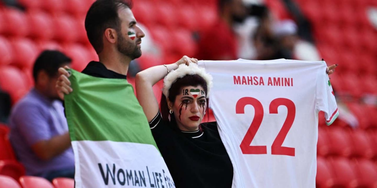 Two young Iranian girls display symbols of local feminism during an Iranian national team match at the World Cup in Qatar.